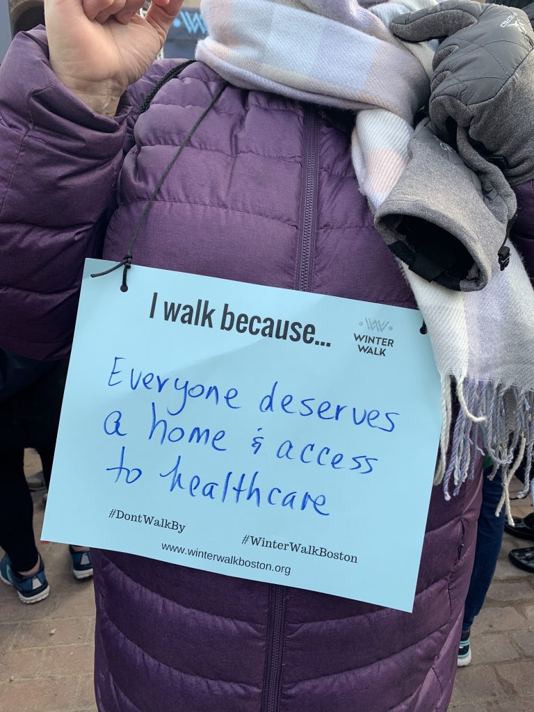 Walkers in Copley Square wear signs explaining their motivation to join the Winter Walk. Photo by Maria Aguirre.
