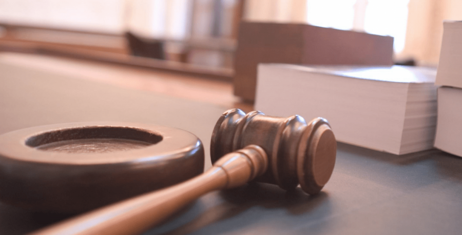 this stock image shows a gavel resting on a judges bench in a courtroom