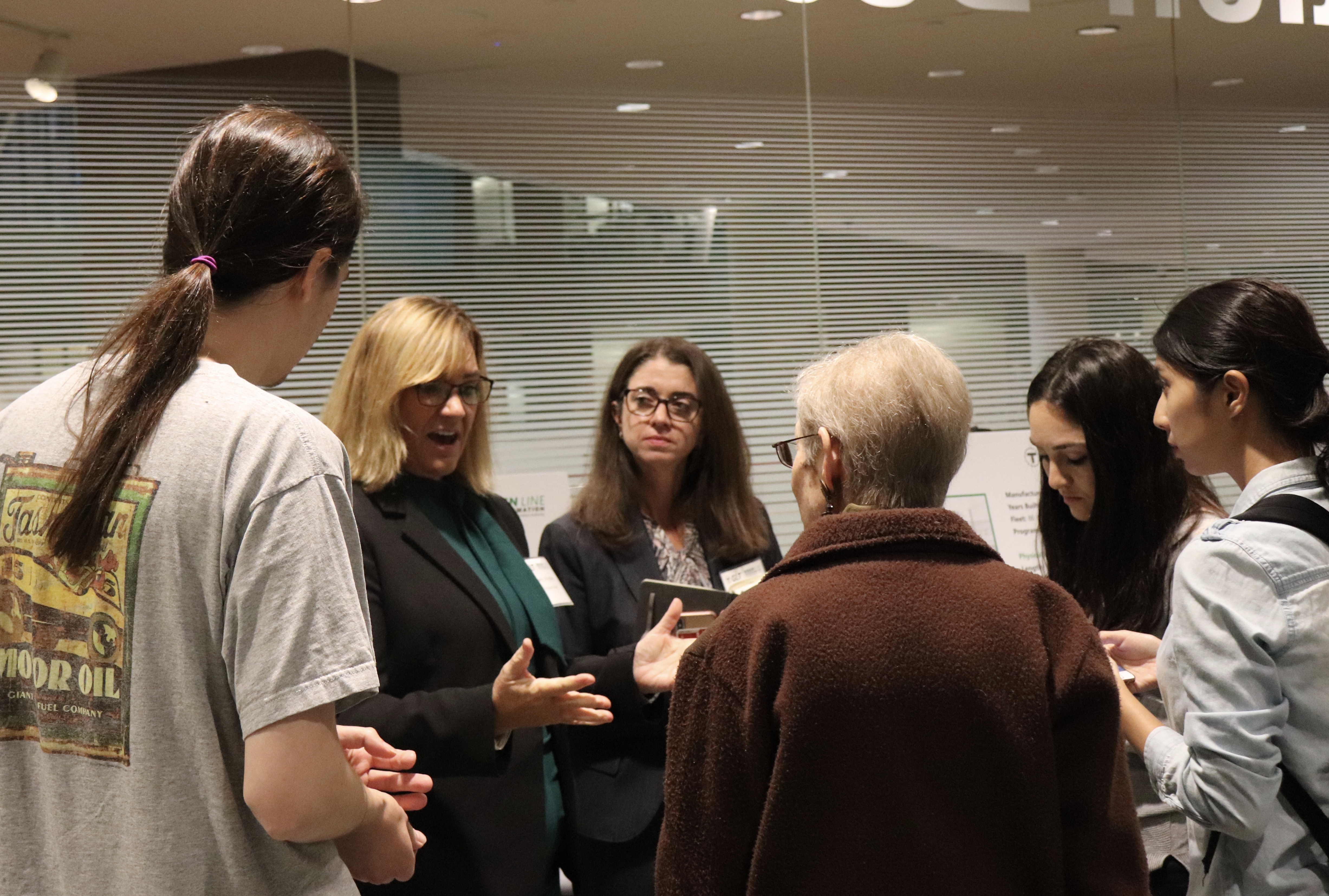 Senior Director Kimberly Woollard (second from left) spoke one-on-one with members of the public after the meeting. Photo by Eileen O'Grady.