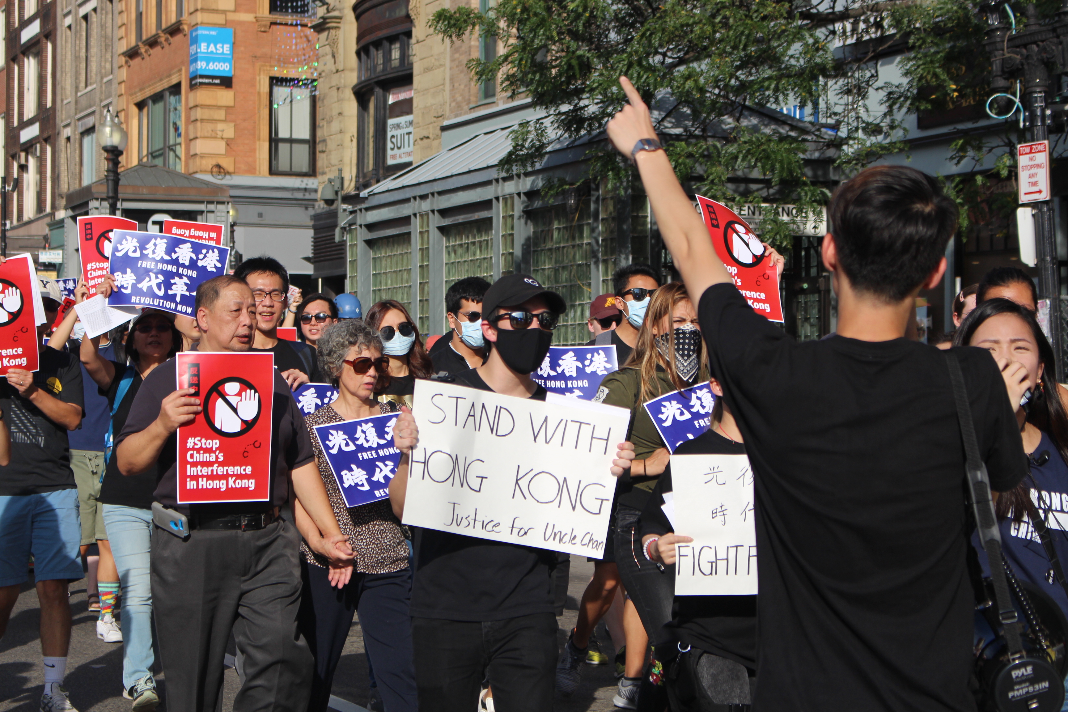 Marchers traveled down Boston's streets carrying banners and wearing masks to hide their identity. Photo by Lex Weaver.