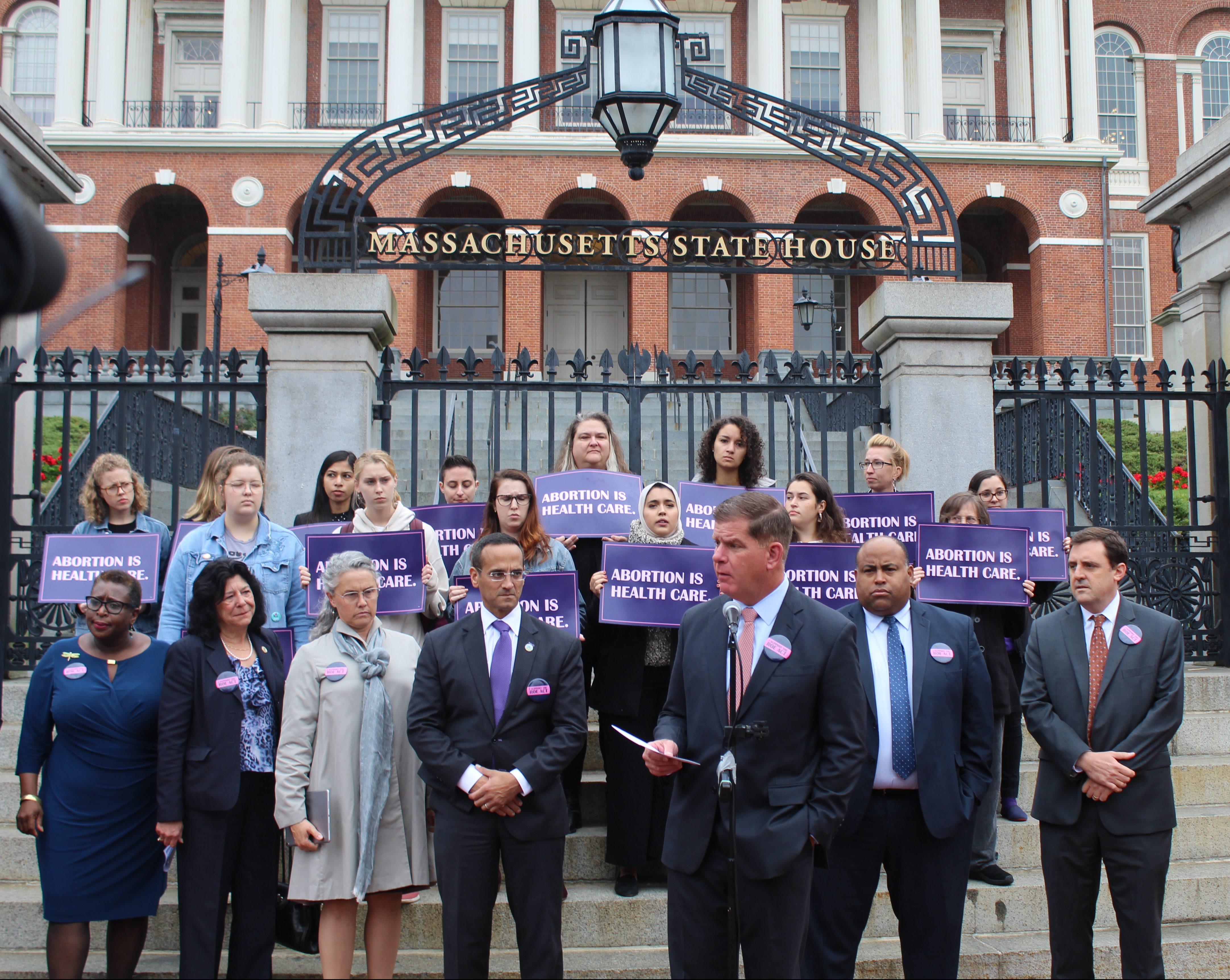 (From left to right) Mayors Yvonne Spicer of Framingham, Donna Holaday of Newburyport, Nicole LaChapelle of Easthampton, Joseph Curtatone of Somerville, Martin Walsh of Boston, Daniel Rivera of Lawrence and Marc McGovern of Cambridge, all stood and some spoke in support of the act that would protect and expand abortion rights and reproductive health care access across Massachusetts. Photo by Catherine McGloin.