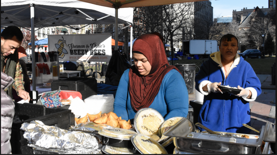 Mehzabin Mitzy Shaikh, owner of Guru the Caterer, serves hearty lunches to customers at the farmers market in Copley Square.