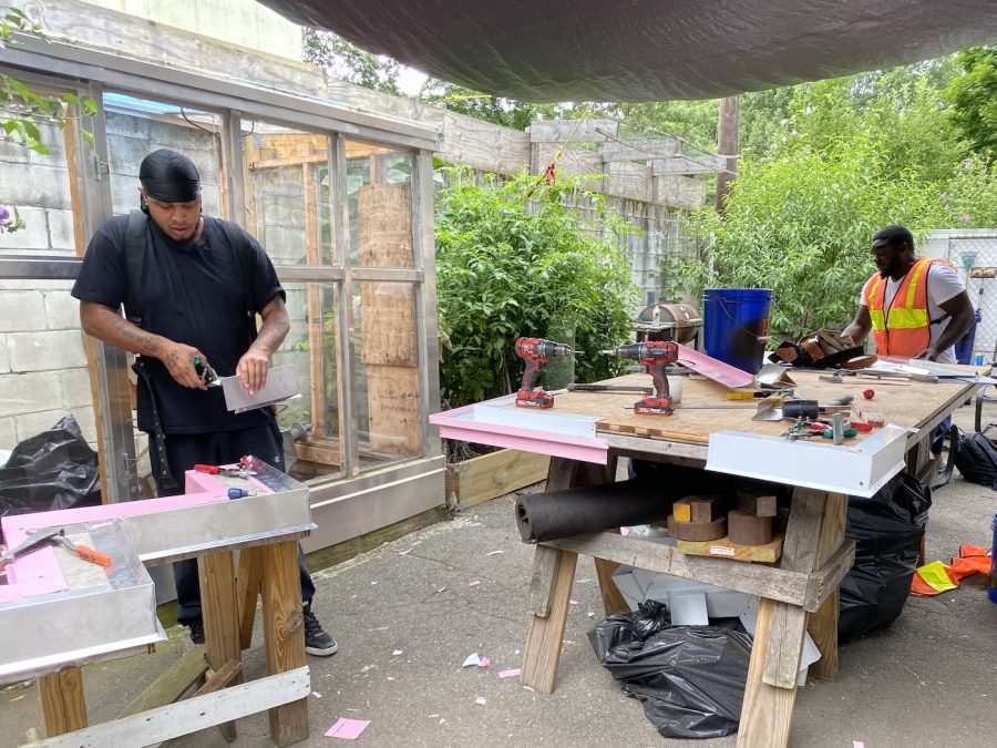 Two of The People's Academy's trainees working in the backyard workshop. Photo: Huilin Li.