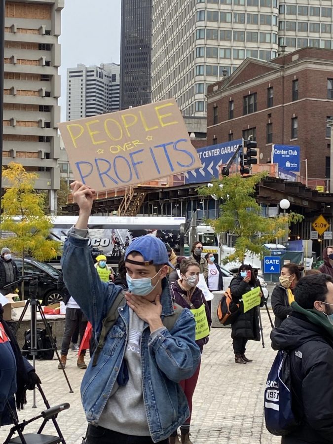Protester holding a sign "people over profit"