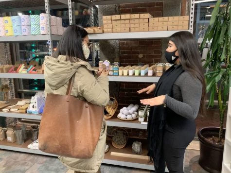 UVIDA shop owner Maria Camila Vasco (right) explains one of her deodorant products to a customer at the North End store.