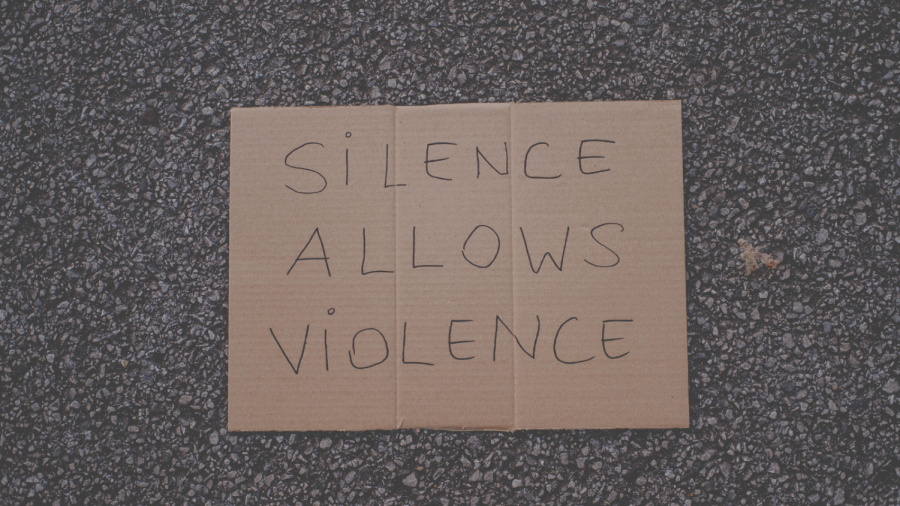 Photograph of a piece of cardboard that says Silence Allows Violence