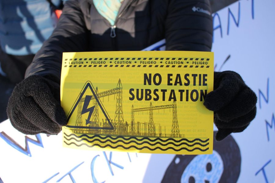 A protester holds a No Eastie Substation flyer at a protest on Condor Street Urban Wild in Chelsea, Mass. on Sunday, Jan. 31.