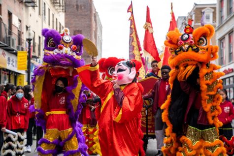 Boston, MA: Jan. 29, 2023 -- Lions and a masked figure dance in the streets of Bostons Chinatown. This years Lunar New Year rang in the Year of the Rabbit. 