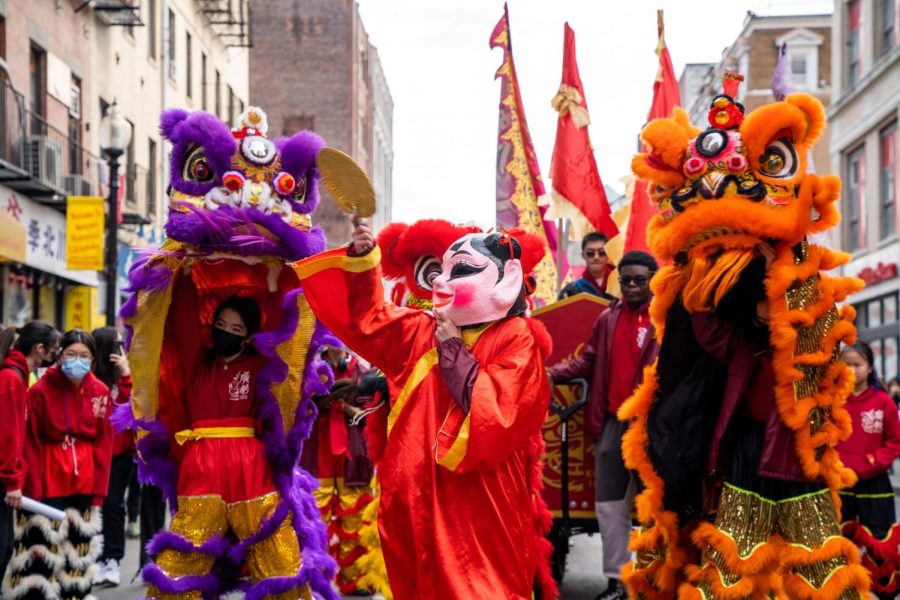 Boston, MA: Jan. 29, 2023 -- Lions and a masked figure dance in the streets of Bostons Chinatown. This years Lunar New Year rang in the Year of the Rabbit. (Photo: Kelly Chan)