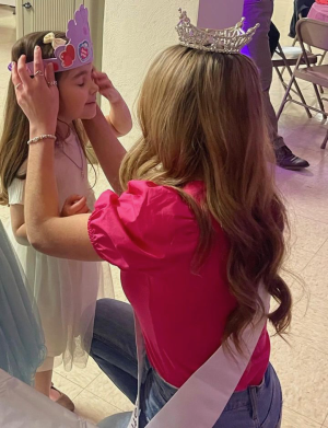 Mya Leonardo adjusts the crown on a young dancer at the Holy Trinity Sweetheart Dance in Fall River, MA on February 17, 2023.