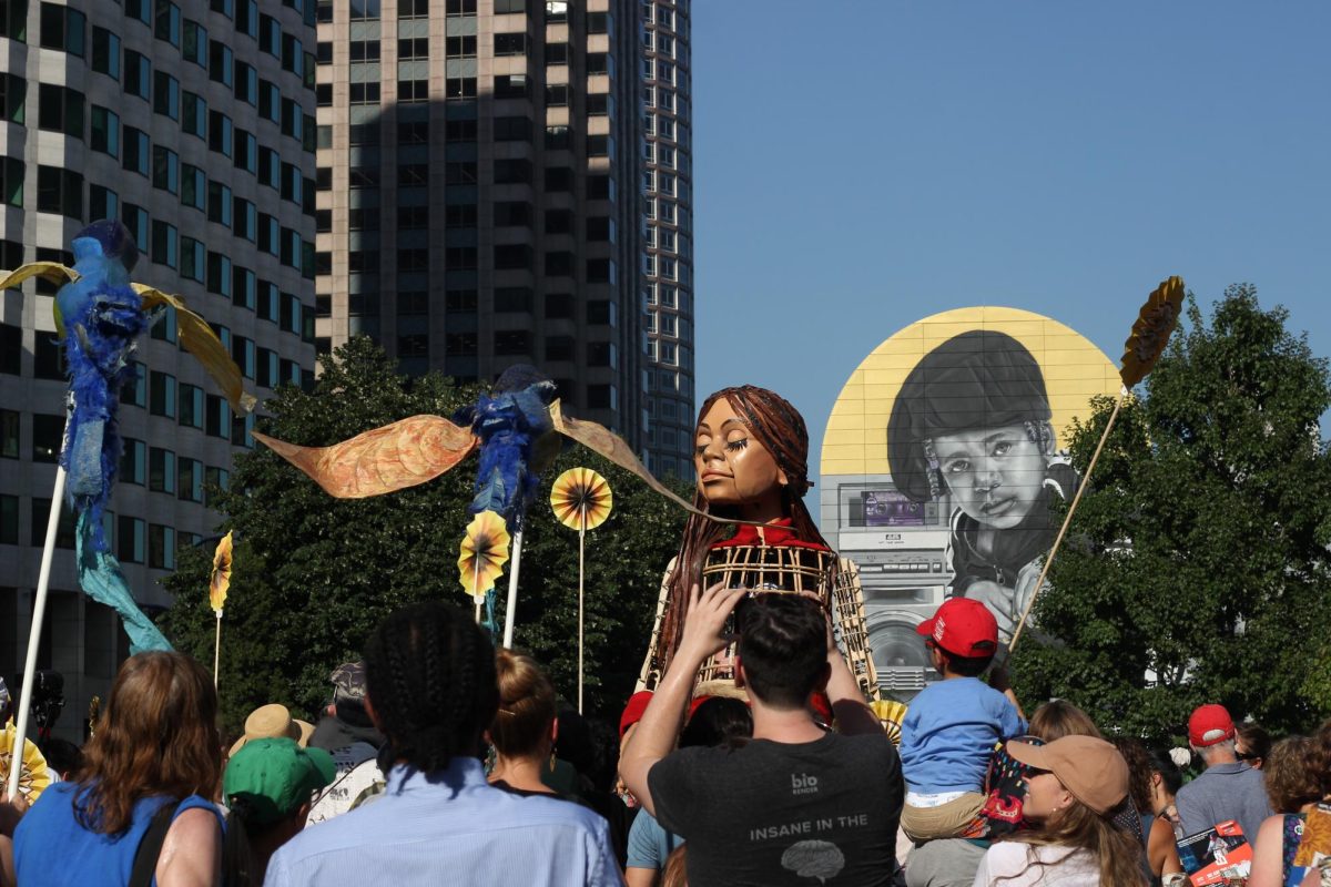Boston, MA: Sept. 9, 2023 — Little Amals design allows her to move in a child-like manner, from her facial expressions to the her stride. Towering over the crowd of admirers around her, the puppet stops every few minutes on her walk, taking a moment to observe her surroundings. 