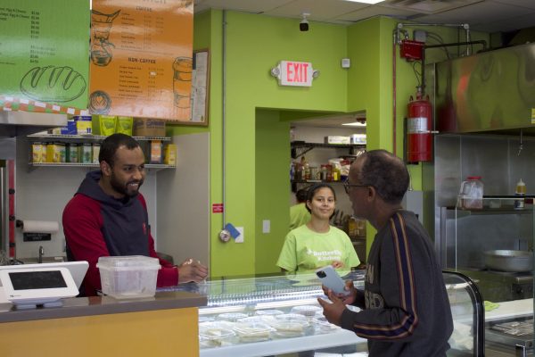 Workers greet Abdillahi Abdirahman, owner of Butterfly Falafel, in Roxbury. Butterfly Falafel is Somali-owned and was opened with the support of Somali Development Center.