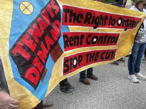 Protestors hold signs outside Boston City Hall. 