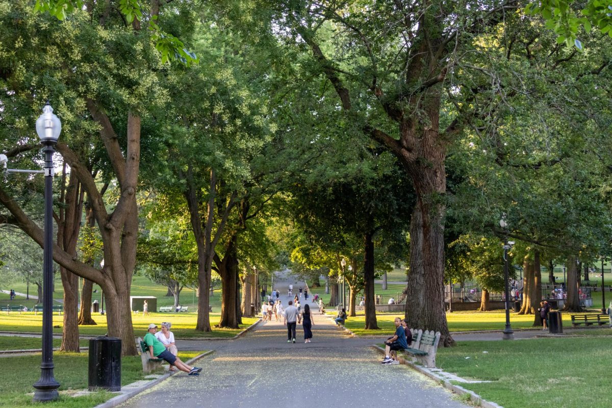 A couple walks through Boston Common holding hands. The park is 50 acres in size and is the oldest city park in the United States.
