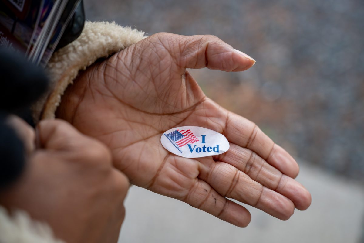 A campaigners hand held an “I Voted” sticker in Roxbury.