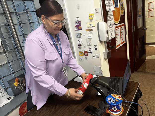 Kiara Rosario, coordinator of the Rox Box food pantry scanning an item for a customer.